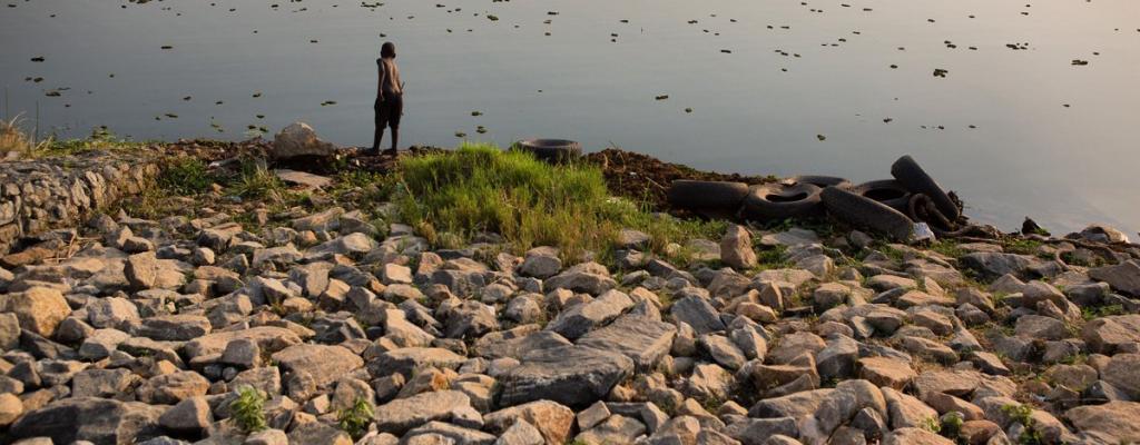 #htmlcaption-0 A boy is seen fishing by the shores of River Nile in Moyo district